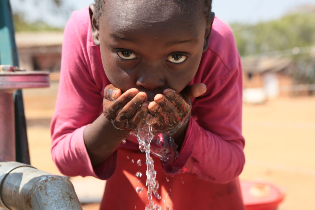 Zimbabwaans meisje dat water drinkt
